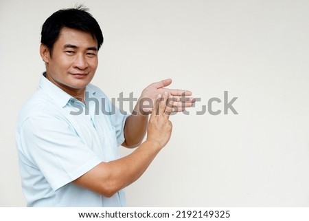 Asian man teacher demonstrate body sign language on white background. Three fingers on palm. Concept : Sign Language to teach or communicate with deaf disabled. Education for handicaps. Translator    