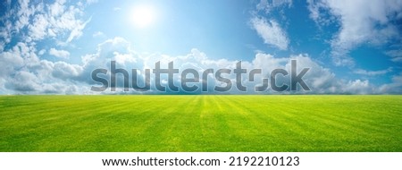 Beautiful natural scenic panorama green field of cut grass into and blue sky with clouds on horizon. Perfect green lawn on summer sunny day. Royalty-Free Stock Photo #2192210123