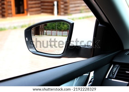 Rear view mirror with beautiful reflection. View from inside the car. Side rear-view mirror on a modern car. Close up rearview mirror lux car. Royalty-Free Stock Photo #2192228329