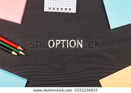 OPTION - text, stickers and colored pencils on a black wooden table. Business concept: buying, selling, commerce (copy space).