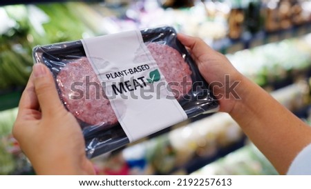 Close-up hand carry choose zero pork soy bean faux peas cutlet gluten free read beyond non-meat lab label. Buy raw fake beef tray in asia store veggie burger patty for health care eat diet meal cook. Royalty-Free Stock Photo #2192257613