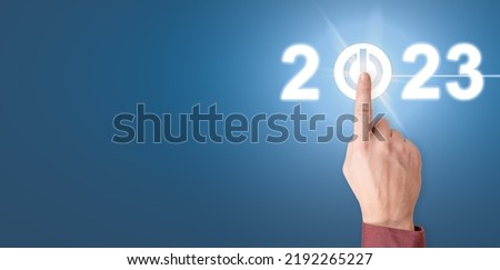 Finger pressing start 2023 button on virtual interface. Businessman pressing 2023 start up business. Happy New Year button technology virtual innovation concept. start button 2023. blue background Royalty-Free Stock Photo #2192265227