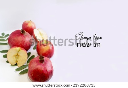 A picture of a pomegranate and an apple with text in Hebrew that says Happy New Year and Happy Holidays in honor of a Jewish holiday