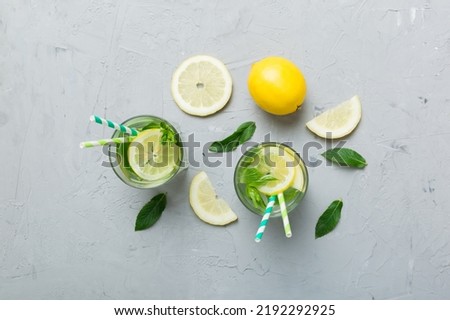 Caipirinha, Mojito cocktail, vodka or soda drink with lime, mint and straw on table background. Refreshing beverage with mint and lime in glass top view flat lay.