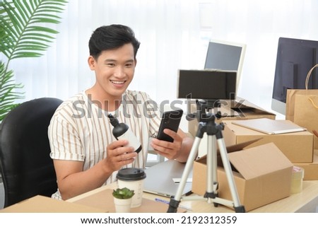Portrait photo of a young handsome Asian adult man, livestream to sell goods online, concept of personal commerce reseller business of digital life 
