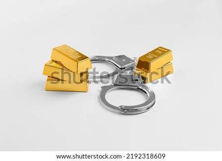 Handcuffs and gold bars on a white background. Crime and Punishment. Theft of gold is punishable. Honest business.