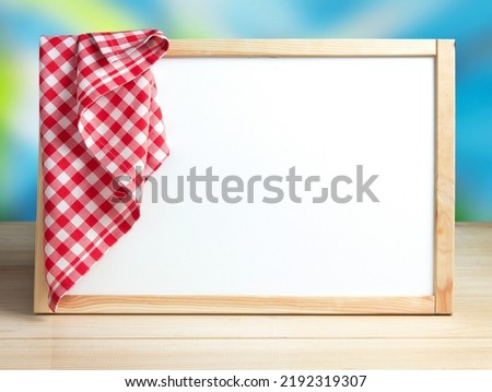 White board in frame with picnic cloth on it.Recipe menu food service background empty copy space.Restaurant business advertisement design concept.