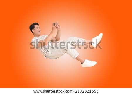 Portrait banner of a young handsome Asian adult man, floating and using smart phone, isolated on color background. concept of smart phone entertainment Royalty-Free Stock Photo #2192321663
