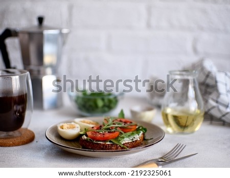 Balanced breakfast of sandwich with cheese, tomatoes, green and hot coffee on light background. Diet food.