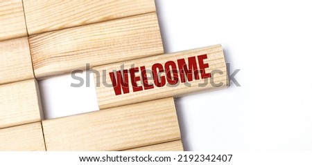 On a light background, wooden blocks with the text WELCOME. Close-up top view.