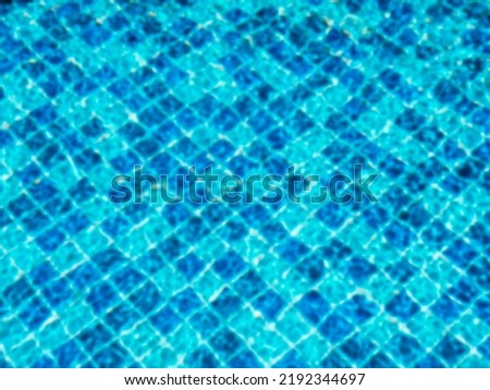 Blurred pool background. Blurry on top view of empty of blue mosaic tiles grid pattern in swimming pool. Empty space on the water surface, summer background.