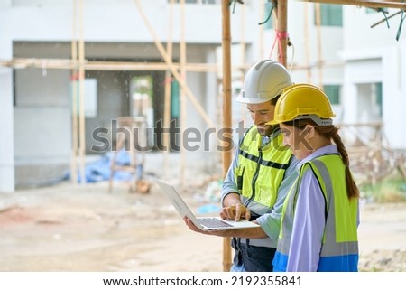 Team of foreman are working and discussing by laptop on construction building site