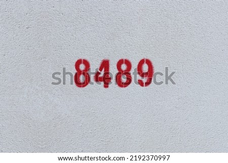 Red Number 8489 on the white wall. Spray paint.
