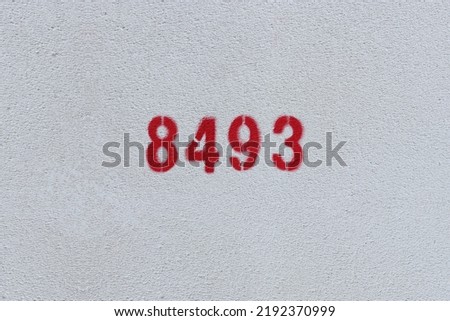 Red Number 8493 on the white wall. Spray paint.

