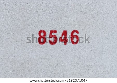 Red Number 8546 on the white wall. Spray paint.
