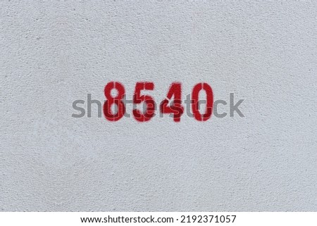 Red Number 8540 on the white wall. Spray paint.
