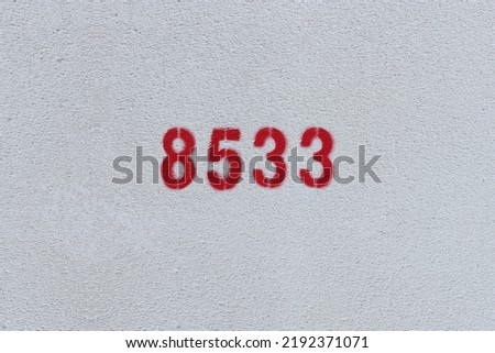 Red Number 8533 on the white wall. Spray paint.
