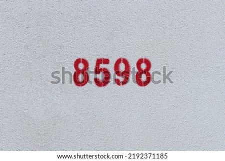 Red Number 8598 on the white wall. Spray paint.
