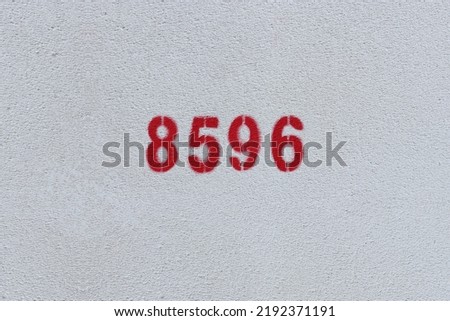 Red Number 8596 on the white wall. Spray paint.
