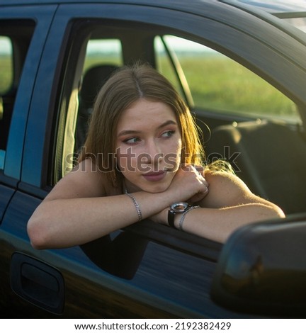 Girl sticking her hands out of a car window
