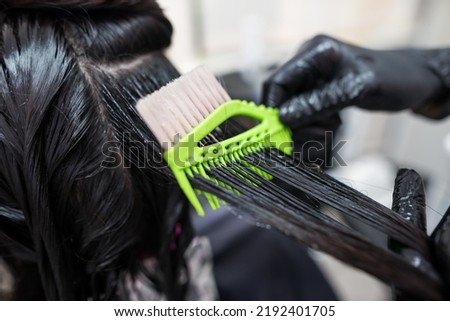 The hairdresser applies professional liquid keratin to the client's hair. A girl does keratin hair strengthening in a beauty salon. Hair care. Royalty-Free Stock Photo #2192401705