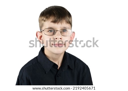 A young boy in glasses and a dark shirt on a white background, the boy has a serious face, for now he is forced to wear glasses so that his vision will be better, eye health concept, isolated