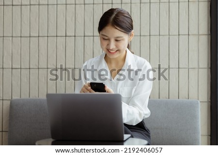 Asian woman using mobile phone, she surfs internet and social media on smartphone, chatting on app with friends. The concept of using technology in communication and the use of the Internet.