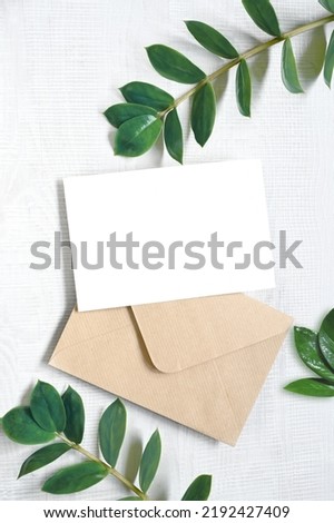 Mock up card with plants. Invitation card with grey envelope on white background.