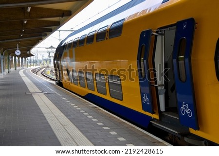 Roermond - Limburg - Netherlands, May 2022 yellow and blue Dutch NS (Nederlandse Spoorwegen) train.
Open doors with a bicycle and symbol indicating the entrance for bicycles or wheelchairs
