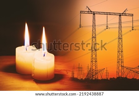 Burning flame candle and power lines on background. Energy outage and blackout. Energy crisis. Price increase of electricity for home and industry. Royalty-Free Stock Photo #2192438887