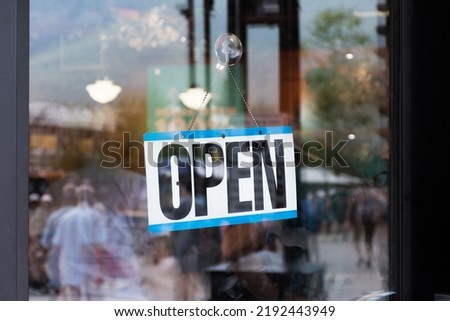 Open sign hanging in storefront window business shop closeup