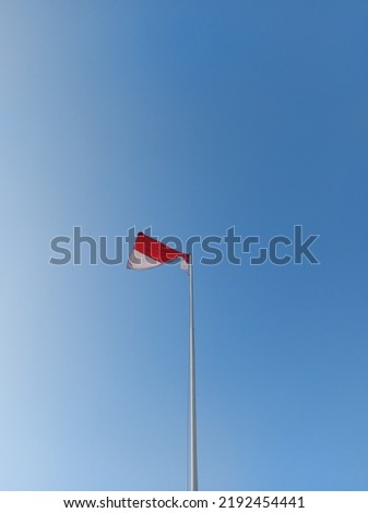 Indonesia's red and white flag flutters against the sky on a iron pole