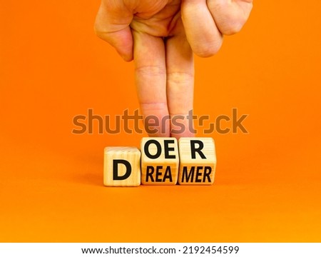 Doer or dreamer symbol. Concept words Doer or dreamer on wooden cubes. Businessman hand. Beautiful orange table orange background. Business and doer or dreamer concept. Copy space. Royalty-Free Stock Photo #2192454599
