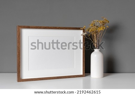 Landscape wooden frame mockup with dry flowers in vase, blank mockup with copy space