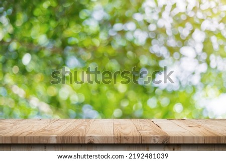 green leaf bokeh blurred and wood table for nature background