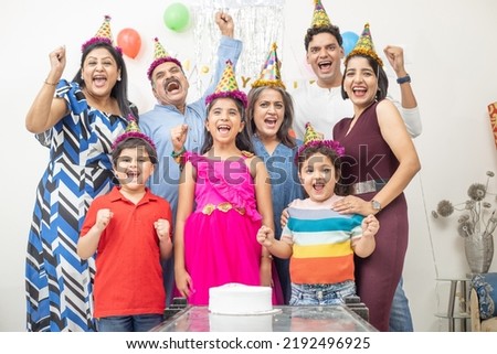 Cheerful indian asian generational family celebrate indoor birthday party. Royalty-Free Stock Photo #2192496925