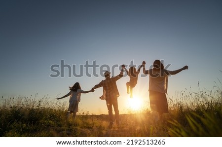 Happy family in the park. Father, mother and children are running, having fun and enjoying summer evening. Royalty-Free Stock Photo #2192513265
