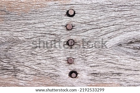 Rusty nail in old brown wood background with nature texture
