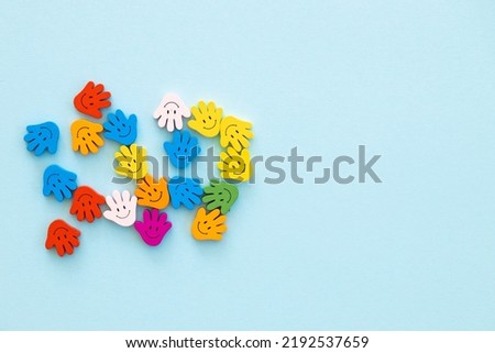 Colored wooden figures in the form hand with smiles on a blue background