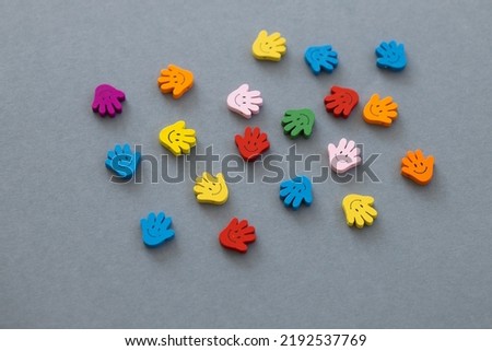 Colored wooden figures in the form hand with smiles on a grey background