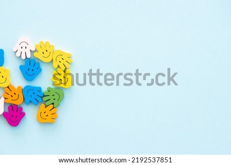 Colored wooden figures in the form hand with smiles on a blue background