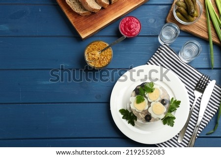 Delicious aspic with meat served on blue wooden table, flat lay. Space for text
