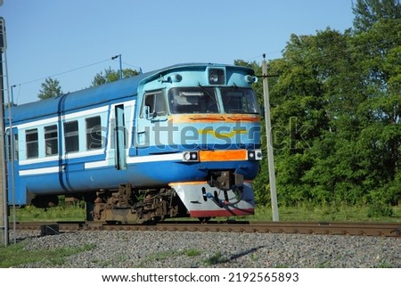 Old Russian suburban passenger train on countryside forest background drive on one way railway at summer day