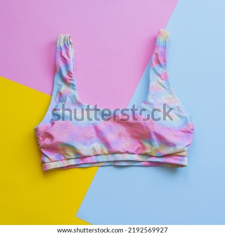 A bra from a rainbow-colored swimsuit in the style of minimalism on a colorful bright background.