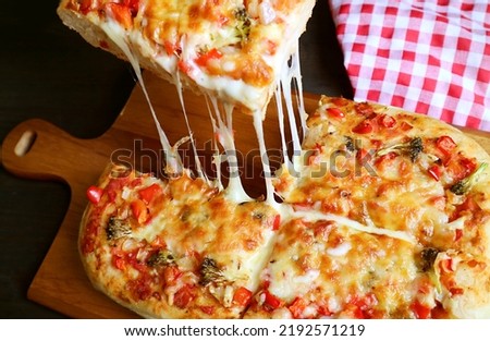 Slice of Homemade Pizza Alla Pala with Mouthwatering Stretching Cheese Being Taken from the Breadboard