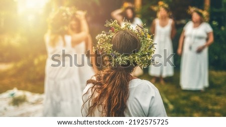 Women in flower wreath on sunny meadow, Floral crown, symbol of summer solstice. Royalty-Free Stock Photo #2192575725