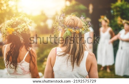 Women in flower wreath on sunny meadow, Floral crown, symbol of summer solstice. Royalty-Free Stock Photo #2192575729