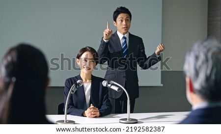 Asian woman and sign language interpreter at press conference. Royalty-Free Stock Photo #2192582387