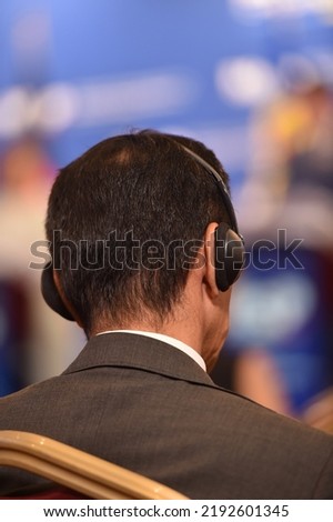 Man using translation headphones during a press conference