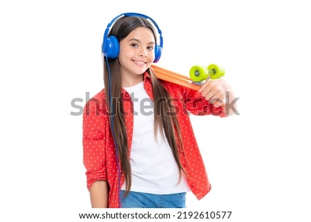 Teen girl 12, 13, 14 years old with skateboard and headphones over white studio background. Cool modern teenager in stylish clothes. Teenagers lifestyle, casual youth culture. Royalty-Free Stock Photo #2192610577